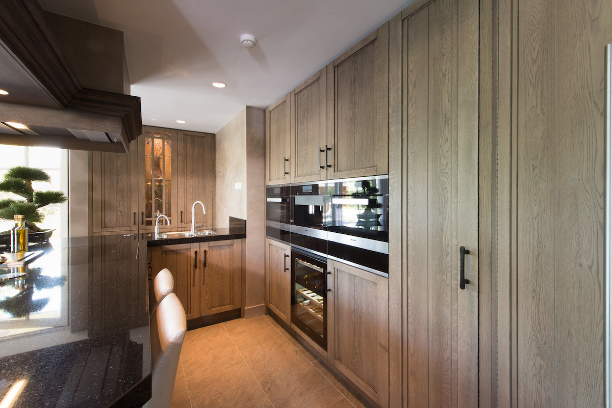 Klassieke houten keuken met bar en moderne Miele apparatuur via Tieleman Keukens