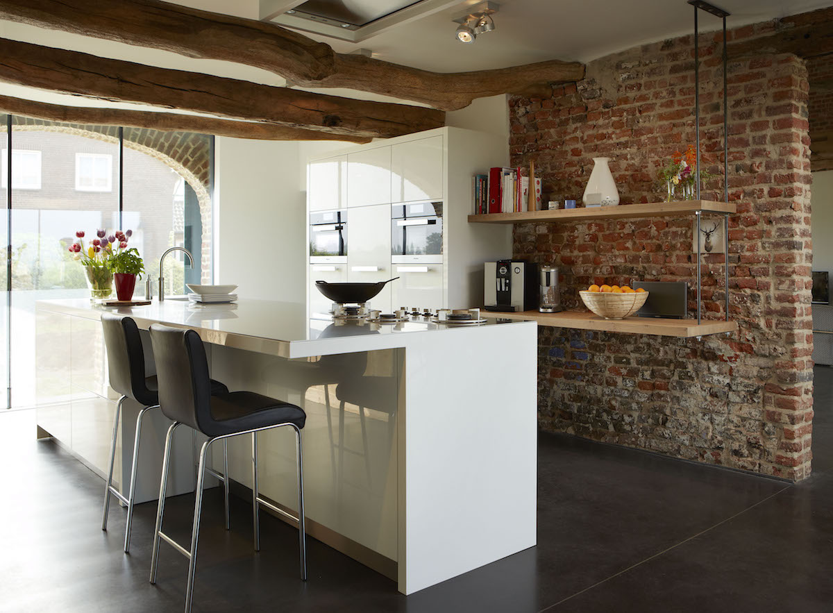Moderne witte hoogglans keuken met kookeiland en ontbijtbar voorzien van Miele keukenapparatuur. Via Harold Lenssen Keukens 