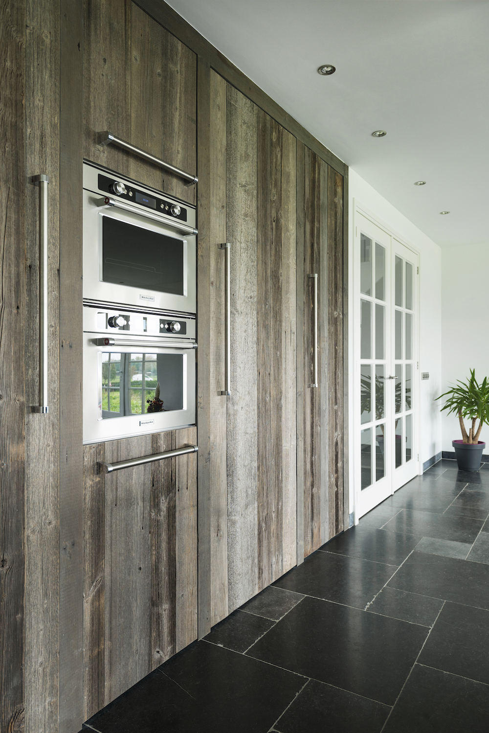 Houten keuken van RestyleXL met hoge houten kastenwand, inbouwapparatuur van KitchenAid inbouwapparatuur #restylexl #houtenkeuken #keuken #kitchenaid
