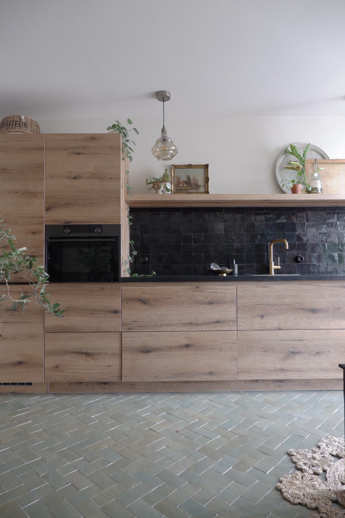 Designtegels houten keuken. Vloertegels Platta Vert Gris Foncee en op de achterwand Zellige Noir #keukentegels #designtegels #tegels #keuken #vloertegels #achterwand #houtenkeuken